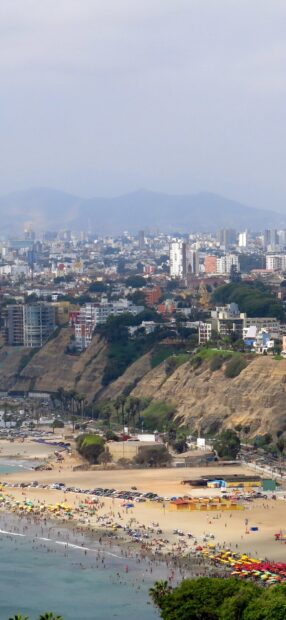 The Lima Peru cityscape shows crowded beach and cliffs with buildings, HD Mobile Wallpaper