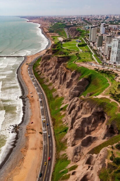 Aerial view of Lima Peru coastal cliffs with urban buildings and highway, 2K Desktop Wallpaper