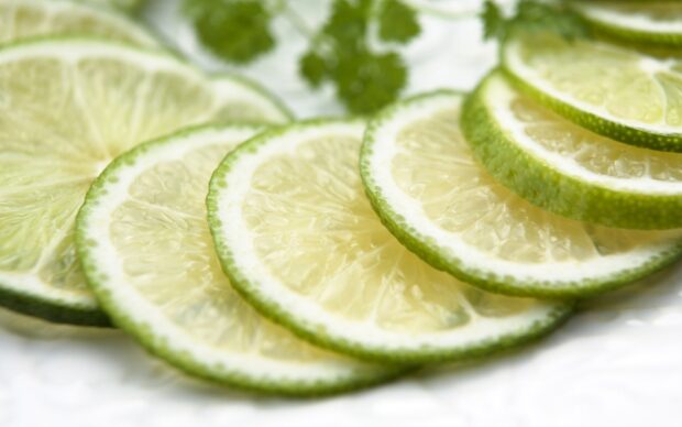 Fresh lime slices arranged in a close up view showing vibrant green citrus fruit