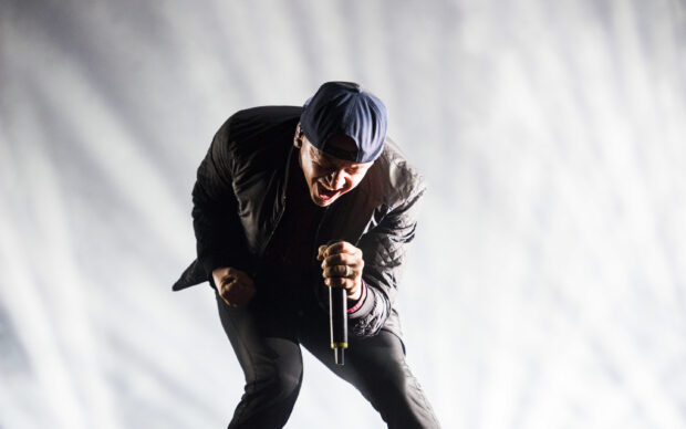 Linkin Park vocalist passionately singing on stage during a live concert performance