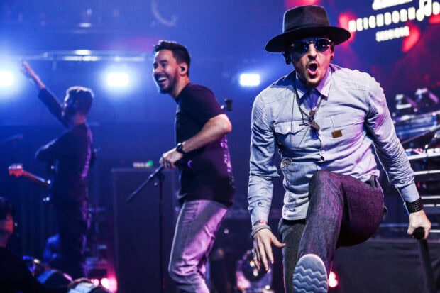 Linkin Park band members performing live on stage during a concert event