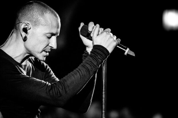 Linkin Park singer holding microphone passionately during performance on stage