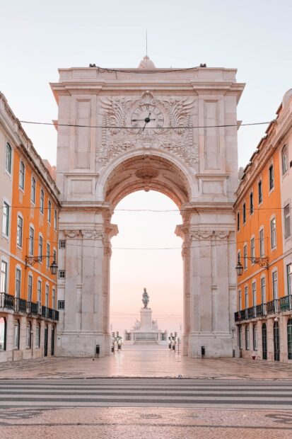 A detailed archway in Lisbon Portugal with a statue visible through the opening, HD Mobile Wallpaper
