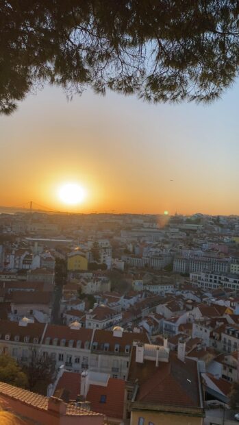 The Lisbon Portugal skyline is captured during a warm sunset with city rooftops, 4K Mobile Wallpaper