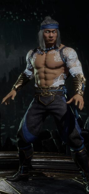 Liu Kang standing with detailed tattoos and blue attire in a dark environment