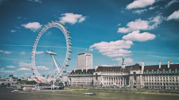 The London Eye stands tall beside the River Thames with historic buildings, 2K Desktop Wallpaper