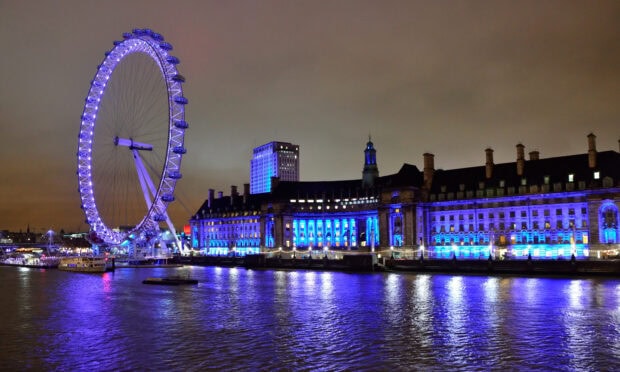 The London Eye is illuminated with blue lights beside the river in London at night, 2K Desktop Wallpaper