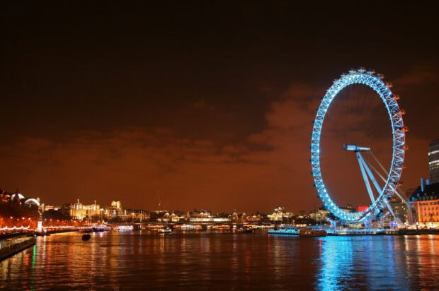 The London Eye is brightly illuminated against the night sky along the River Thames, 2K Desktop Wallpaper