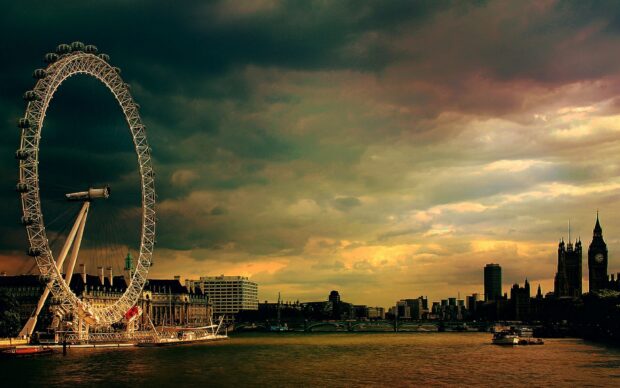 The London Eye stands tall beside the River Thames under a cloudy sky, London landmarks visible, 2K Desktop Wallpaper