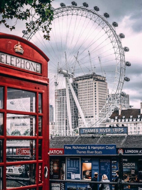 A red telephone booth near the London Eye and river boat office, HD Mobile Wallpaper
