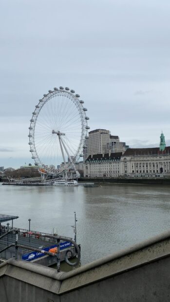 The London Eye stands tall next to the river with city buildings in the background, 4K Phone Wallpaper