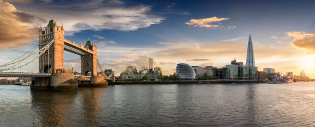 The London skyline features Tower Bridge and modern buildings at sunset by the river, 2K Desktop Wallpaper