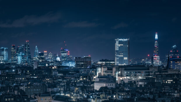 The London skyline features various illuminated skyscrapers under a dark night sky, 4K Desktop Wallpaper