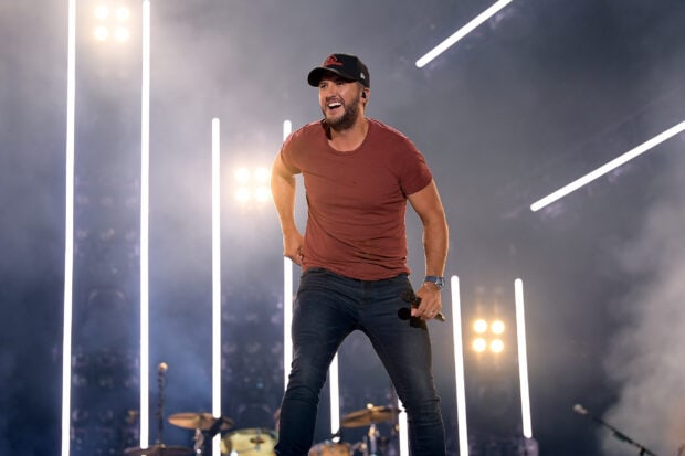Luke Bryan is smiling on stage during a live performance, HD Desktop Wallpaper