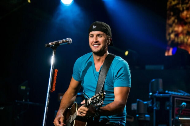 Luke Bryan is playing guitar and singing during a concert, 2K Desktop Wallpaper