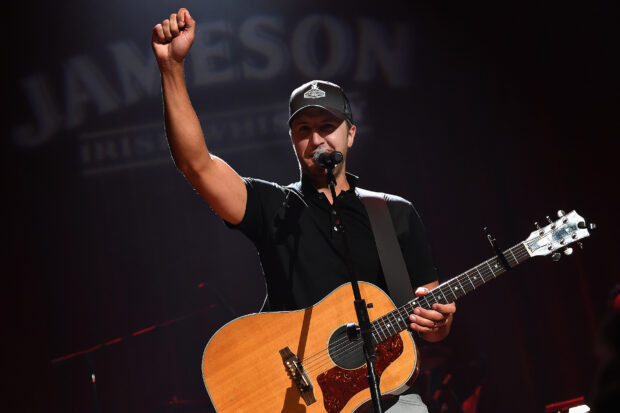 Luke Bryan is performing with his guitar and microphone during a concert, HD Desktop Wallpaper