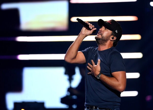 Luke Bryan is passionately singing with a microphone during a live concert, HD Desktop Wallpaper