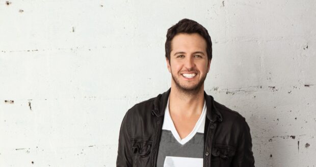 Luke Bryan is smiling wearing a black jacket against a white wall, 2K PC Wallpaper
