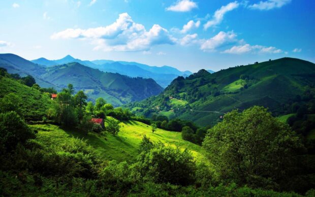 The green hills display vibrant shades under a partly cloudy sky, HD Desktop Wallpaper