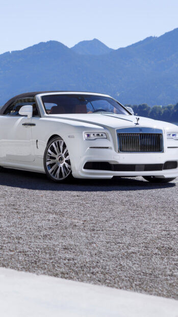 A white Rolls Royce Dawn is parked on gravel with mountains in the background, 4K Phone Wallpaper