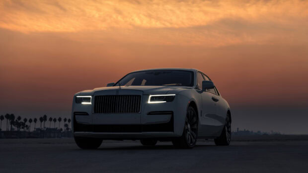A luxury Rolls Royce Ghost car is parked outdoors during a colorful sunset, 4K Desktop Wallpaper