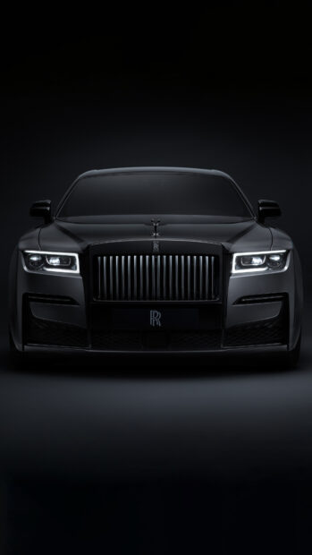 A black Rolls Royce Ghost is shown from the front with illuminated headlights in a dark environment, 4K Phone Wallpaper