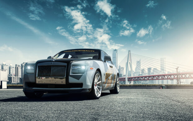 A Rolls Royce Ghost is parked on an empty street with modern city buildings and a bridge in the background, HD Desktop Wallpaper