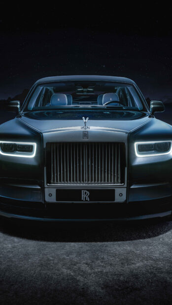 A Rolls Royce Phantom is shown with illuminated headlights and elegant design at night, 4K Phone Wallpaper