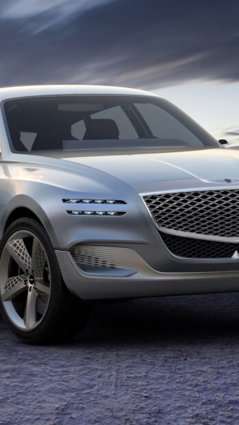 The silver Genesis car front view captures its sleek and modern design under a dusky sky, 4K Phone Wallpaper
