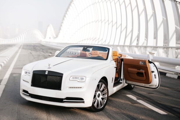 Rolls Royce Dawn parked on a bridge with its door open under a bright sky, HD Desktop Wallpaper