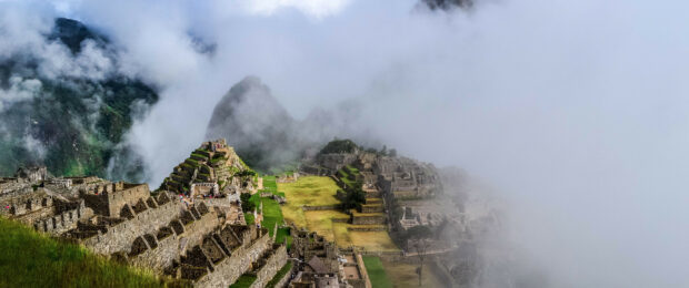Ancient Machu Picchu stone terraces surrounded by mist and mountains in Peru