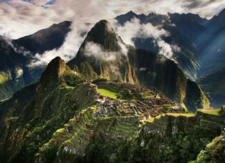 Machu Picchu ancient ruins surrounded by lush green mountains and mist