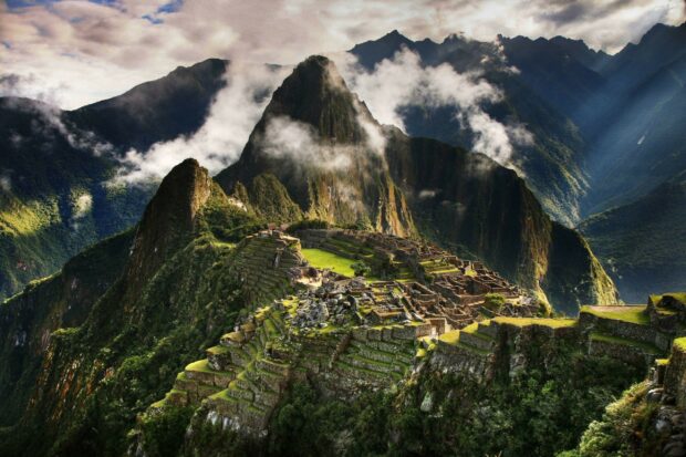 Machu Picchu ancient ruins surrounded by lush green mountains and mist