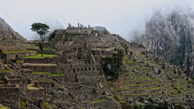 Ancient Machu Picchu ruins surrounded by mountains and mist in high definition