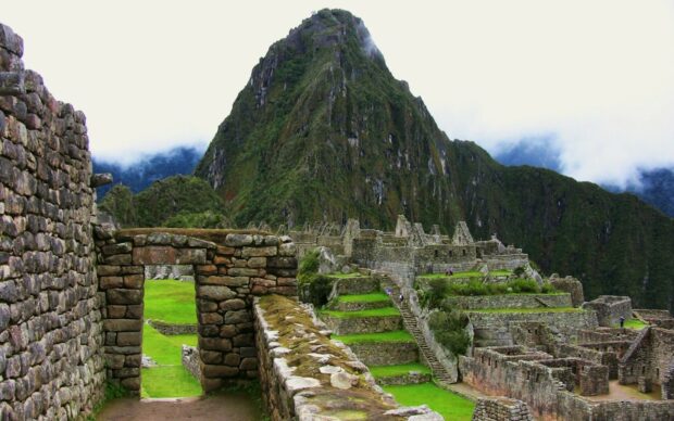 Ancient Machu Picchu stone structures surrounded by lush green mountains
