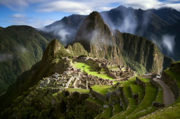 Ancient Machu Picchu ruins surrounded by lush green mountains and misty clouds