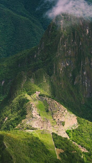 Ancient Machu Picchu ruins surrounded by lush green mountains in HD quality