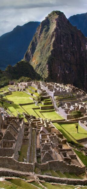 Ancient Machu Picchu ruins surrounded by lush mountains and green terraces