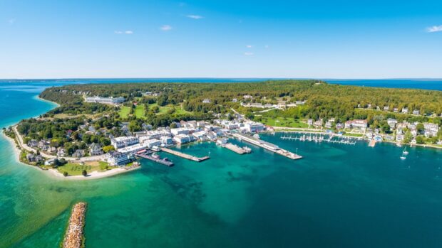 Aerial view of Mackinac Island with clear blue water and green landscape, 2K Desktop Wallpaper