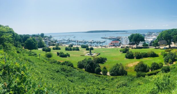 A scenic view of Mackinac Island featuring lush greenery and boats in the harbor, 2K Desktop Wallpaper