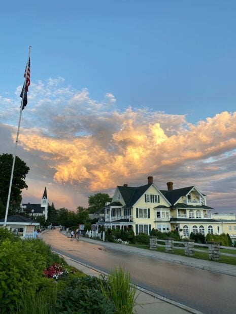 A peaceful street scene on Mackinac Island with historic buildings under a vibrant sunset sky, HD Mobile Wallpaper