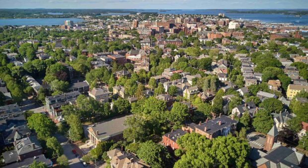 An aerial view of the Maine cityscape showing abundant trees and buildings, 2K Desktop Wallpaper