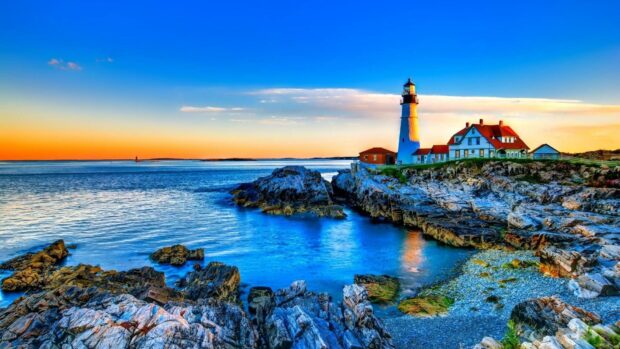 A serene Maine coastline with a lighthouse and rocky shore during sunset, HD Desktop Wallpaper