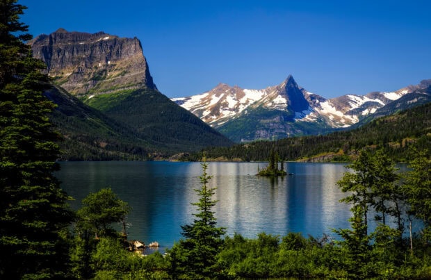 The Glacier National Park features clear lakes and towering mountains under a blue sky, HD Desktop Wallpaper