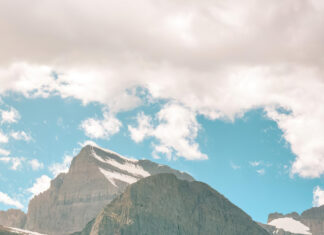 Mountain landscape with snow-capped peaks and turquoise lake.