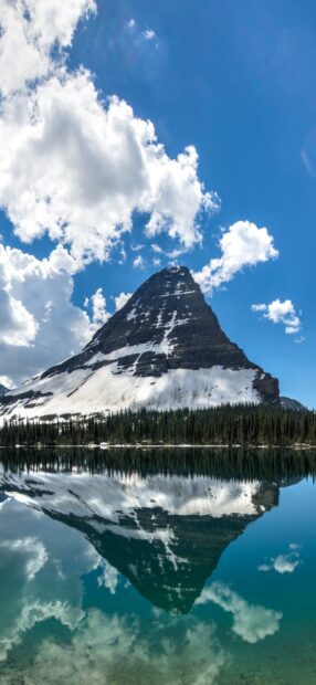 A majestic peak is reflected clearly in the calm waters of Glacier National Park showcasing snow and sky, HD Phone Wallpaper