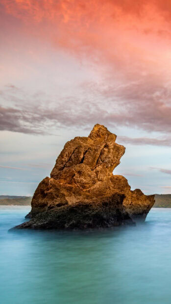 A majestic rock formation stands in calm waters under a colorful sunset sky in Dominican Republic, HD Mobile Wallpaper