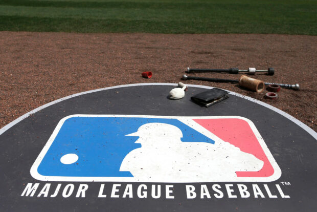 The Major League Baseball logo is displayed on the ground of a baseball field, HD Desktop Wallpaper