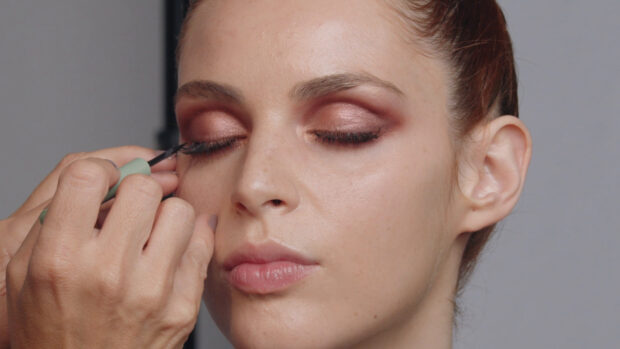 Close up of makeup application on a woman using mascara brush for eyelash detail