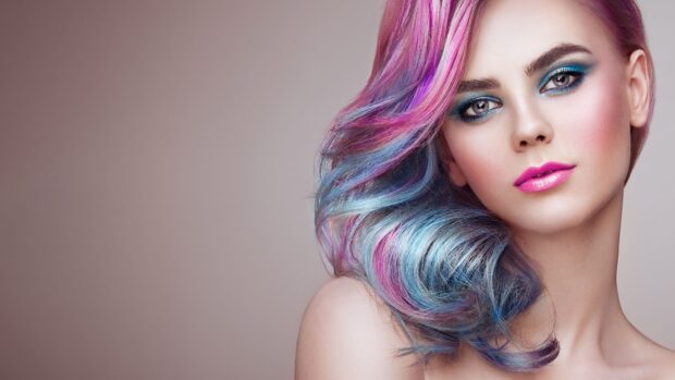 Woman with colorful hair and vibrant makeup showcasing makeup artistry and style